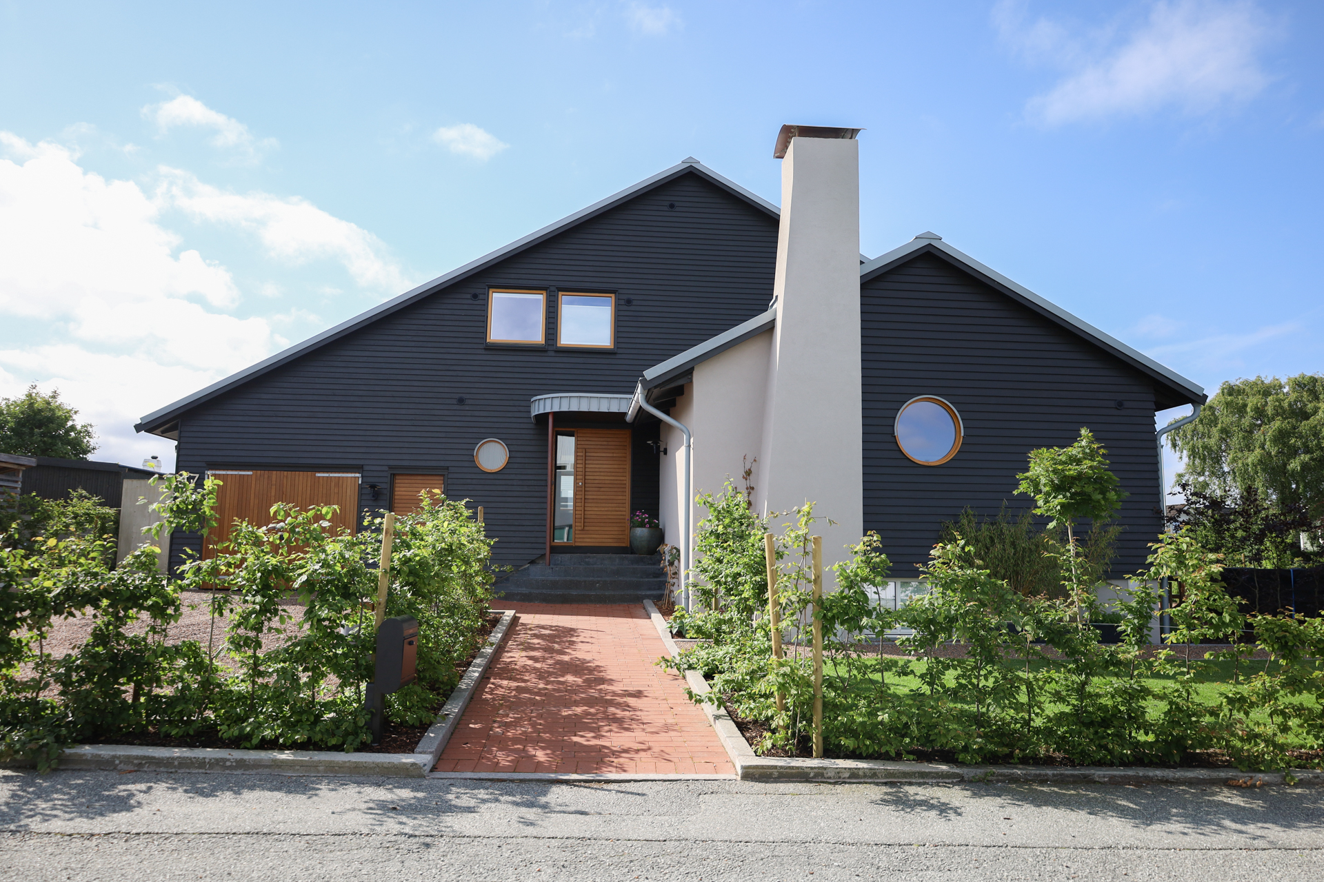 Totalrenovert, svartmalt bolig fra 1959 med runde vinduer, på Madla i Stavanger.